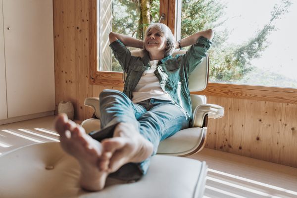 Fröhliche Seniorin in einem Lounge-Chair